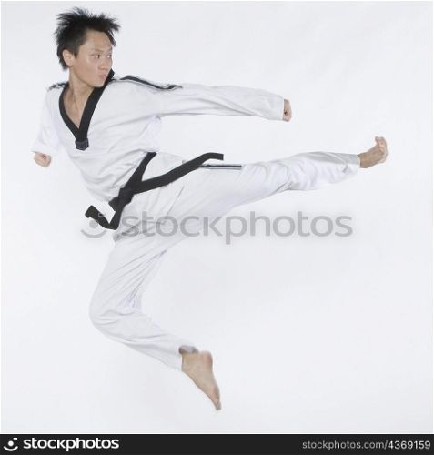 Mid adult man performing flying kick