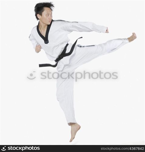 Mid adult man performing round kick