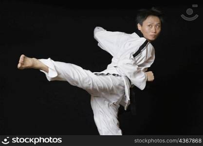 Mid adult man performing the side kick