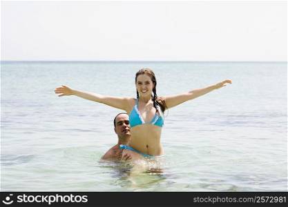 Mid adult man picking up a young woman in the sea