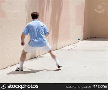Mid adult man playing racquetball on a public court.