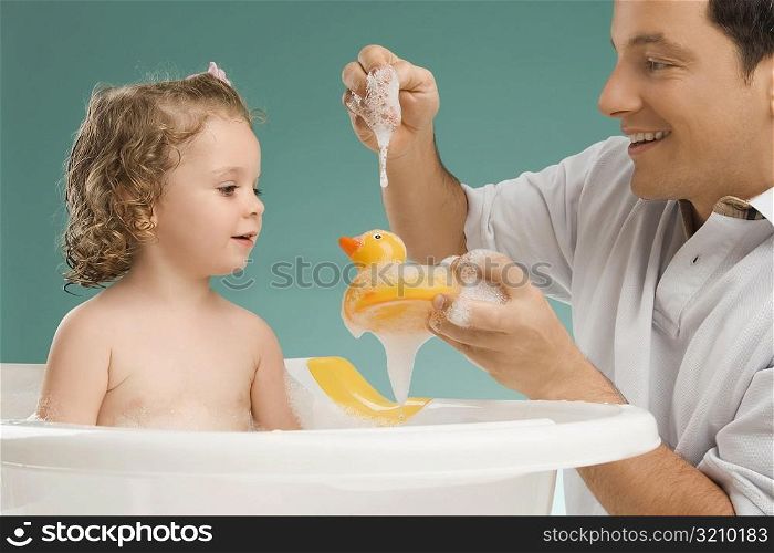 Mid adult man playing with his daughter and smiling