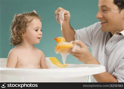 Mid adult man playing with his daughter and smiling