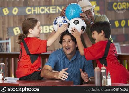 Mid adult man playing with his family in a restaurant