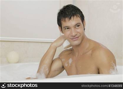 Mid adult man sitting in a bubble bath