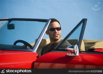 Mid adult man sitting in a convertible car, Miami, Florida, USA