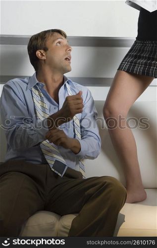 Mid adult man sitting on a couch and looking at a young woman