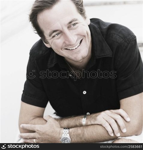 Mid adult man sitting on a staircase and smiling