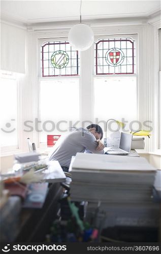 mid adult man sleeps at his desk