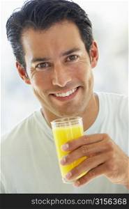 Mid Adult Man Smiling At The Camera And Drinking Orange Juice