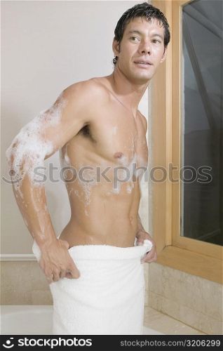 Mid adult man standing in the bathtub