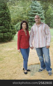 Mid adult man standing with a mature woman in a lawn and smiling