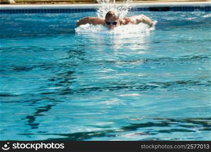 Mid adult man swimming in a swimming pool