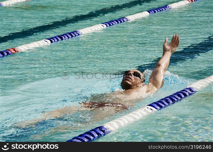 Mid adult man swimming in a swimming pool