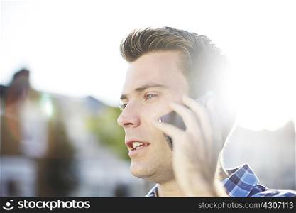 Mid adult man talking on smartphone on street