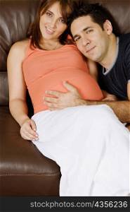 Mid adult man touching pregnant young woman&acute;s abdomen