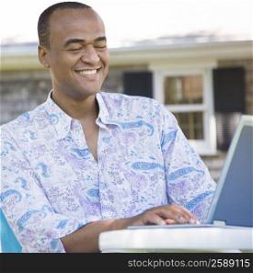 Mid adult man using a laptop and smiling