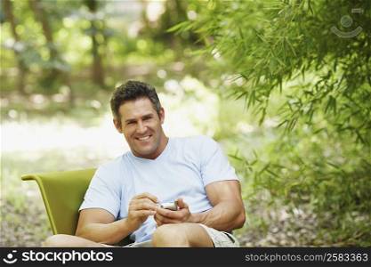 Mid adult man using a personal data assistant