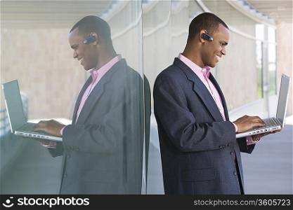 Mid adult man using laptop outdoors