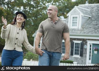 Mid adult man walking in a lawn with a mature woman and smiling