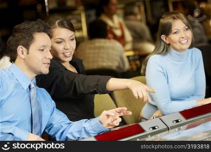 Mid adult man with a teenage girl and a young woman in a casino