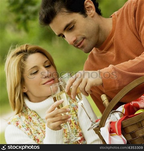 Mid adult man with a young woman toasting with champagne