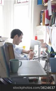 Mid adult man with calculator in home office