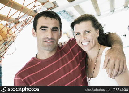 Mid adult man with his arm around a mid adult woman and smiling