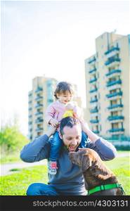 Mid adult man with toddler daughter on shoulders in park