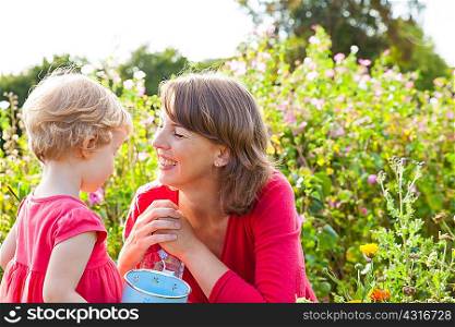 Mid adult mother and toddler daughter in flower field