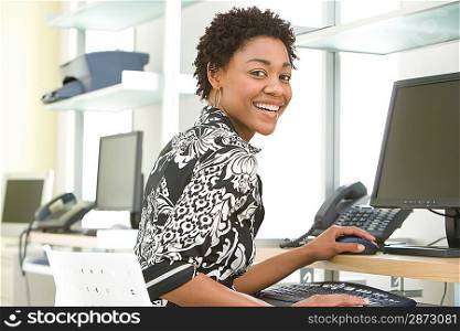 Mid-adult office worker sitting by desk