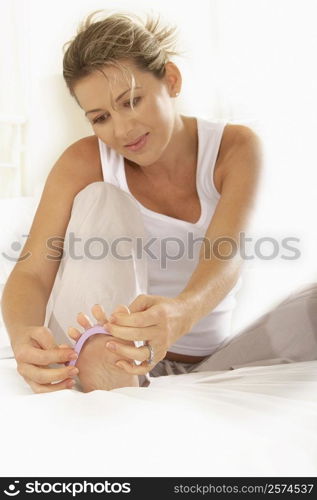 Mid adult woman adjusting her toenail divider