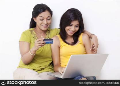 Mid adult woman and her daughter shopping online