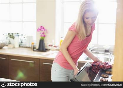 Mid adult woman baking cookies in kitchen