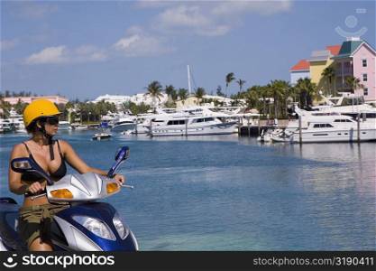 Mid adult woman driving a moped, Paradise Island, Bahamas