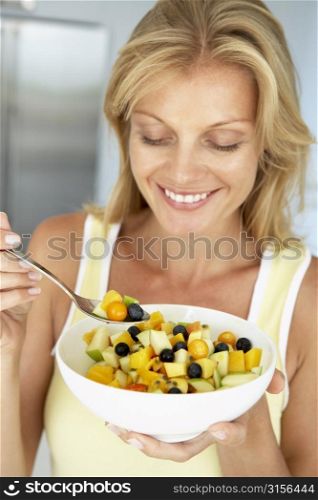 Mid Adult Woman Eating A Bowl Of Fresh Fruit