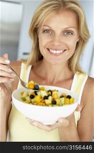 Mid Adult Woman Eating A Bowl Of Fresh Fruit