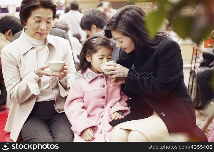 Mid adult woman feeding her daughter