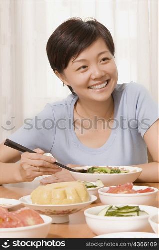 Mid adult woman having food and smiling