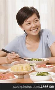 Mid adult woman having food and smiling