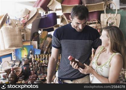 Mid adult woman holding a bottle of sauce with a mid adult man smiling