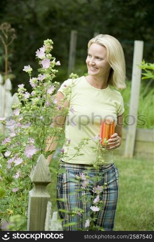 Mid adult woman holding a glass of juice and smiling