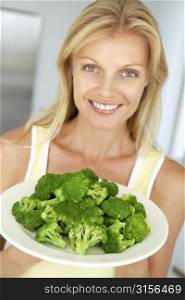 Mid Adult Woman Holding A Plate Of Broccoli
