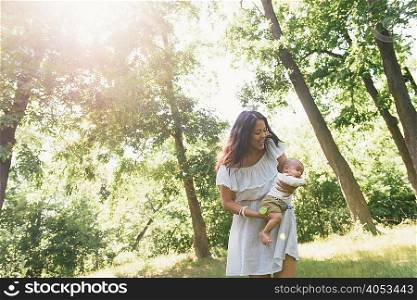 Mid adult woman holding baby son in Pelham Bay Park, Bronx, New York, USA