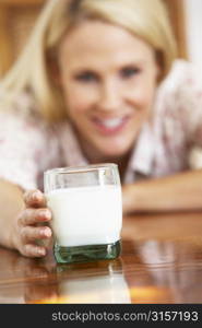 Mid Adult Woman Holding Glass Of Milk, Smiling At Camera