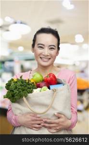 Mid Adult Woman Holding Shopping Bag with Fruits and Vegetables