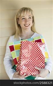 Mid adult woman holding shopping bags and smiling