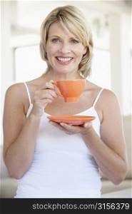 Mid Adult Woman Holding Tea Cup And Smiling At Camera