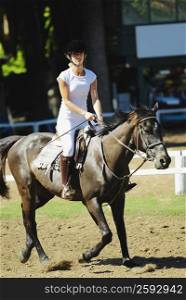 Mid adult woman horseback riding
