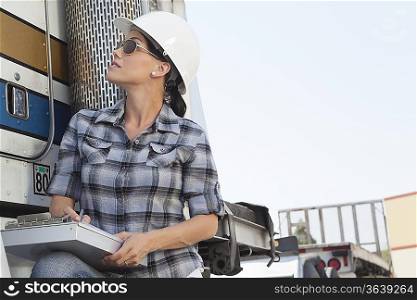 Mid adult woman inspecting timber truck